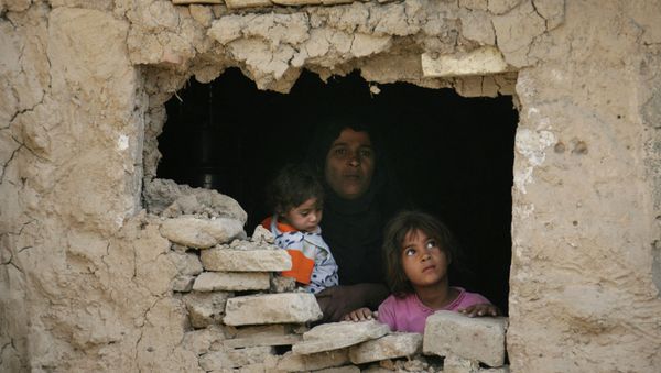 Iraqi family stands inside their home hit by an airstrike in Fidhailiya area in eastern Baghdad, Iraq. - Sputnik International