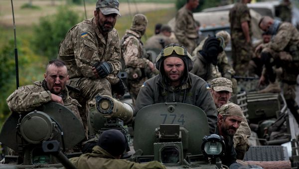 In this photo taken Tuesday, July 14, 2015, Ukrainian servicemen ride atop an armored vehicle near Krasnoarmiisk, Donetsk region, eastern Ukraine - Sputnik International
