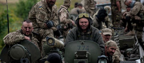 In this photo taken Tuesday, July 14, 2015, Ukrainian servicemen ride atop an armored vehicle near Krasnoarmiisk, Donetsk region, eastern Ukraine - Sputnik International