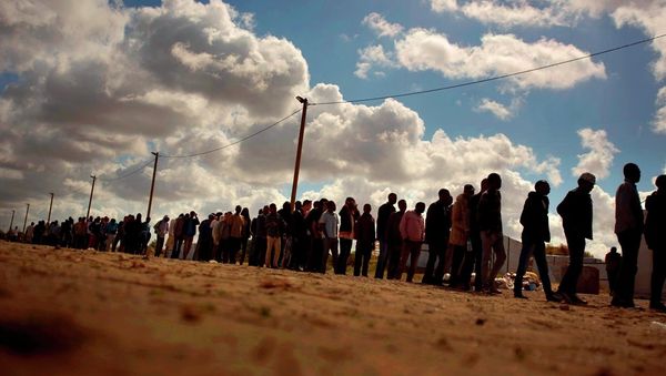 Migrants line up as the wait for a food ration distributed by the Banque Alimentaire of Calais at a camp in northern France, Tuesday, Aug. 4, 2015. - Sputnik International