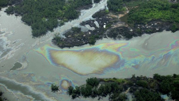 Oil is seen on the creek water's surface near an illegal oil refinery in Ogoniland, outside Port Harcourt. File photo - Sputnik International