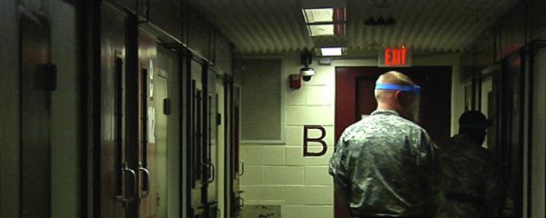 Soldiers walk past detainees' cells during early morning prayer at Guantanamo Bay Naval Base, Camp 5, in Cuba - Sputnik International