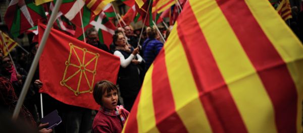 Pro-independence demonstrators of Catalonia and Basque Country raise their regional flags. File photo - Sputnik International