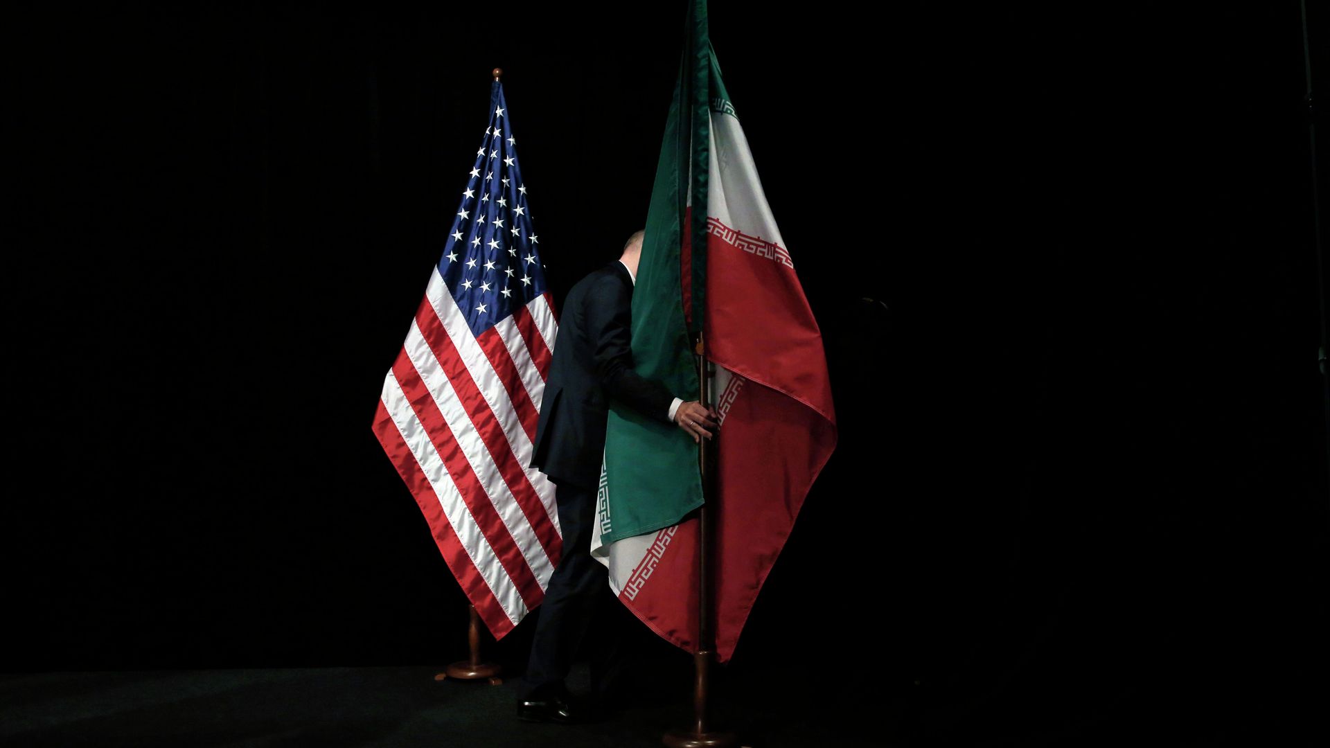 A staff member removes the Iranian flag from the stage after a group picture with foreign ministers and representatives of Unites States, Iran etc. A staff member removes the Iranian flag from the stage after a group picture with foreign ministers and representatives of Unites States, Iran etc. - Sputnik International, 1920, 24.01.2022