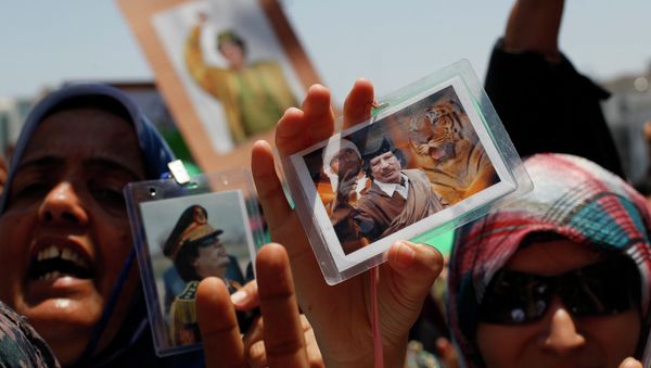 In this file photo taken on a government-organized tour Libyan women show their badges with portraits of Moammar Gadhafi and his son Seif al-Islam as they rally at the Green Square in downtown Tripoli, Libya, on Thursday, June 23, 2011 In this file photo taken on a government-organized tour Libyan women show their badges with portraits of Moammar Gadhafi and his son Seif al-Islam as they rally at the Green Square in downtown Tripoli, Libya, on Thursday, June 23, 2011 - Sputnik International