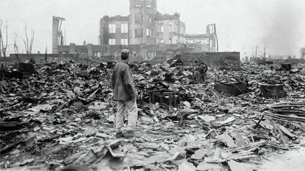 An allied correspondent stands in the rubble in front of the shell of a building that once was a movie theater in Hiroshima, Japan, a month after the first atomic bomb ever used in warfare was dropped by the U.S. on Aug. 6, 1945 - Sputnik International
