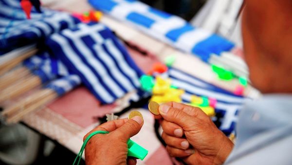 A man holds coins as he prepares to buy Greek flags during a rally organized by supporters of the YES vote to referendum in Athens, June 30, 2015. A man holds coins as he prepares to buy Greek flags during a rally organized by supporters of the YES vote to referendum in Athens, June 30, 2015. - Sputnik International