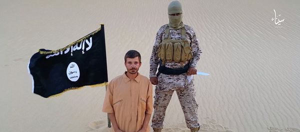 This image made from a militant video posted on a social media website on Wednesday, Aug. 5, 2015, which has been verified and is consistent with other AP reporting, purports to show a militant standing next to another man who identifies himself as 30-year-old Tomislav Salopek, kneeling down as he reads a message at an unknown location - Sputnik International