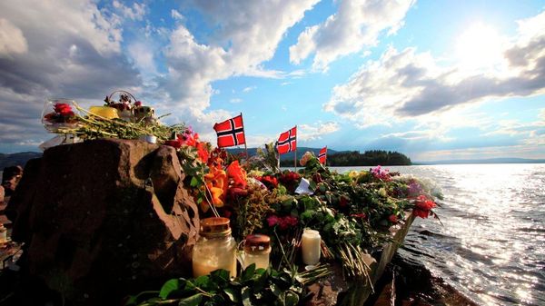 Norwegian flags and flowers are seen in Sundvollen, close to Utoya island, background, where gunman Anders Behring Breivik killed at least 68 people, near Oslo, Norway - Sputnik International