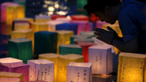 A man prays after releasing a paper lantern on the Motoyasu river facing the Atomic Bomb Dome in remembrance of atomic bomb victims on the 70th anniversary of the bombing of Hiroshima, western Japan, August 6, 2015. A man prays after releasing a paper lantern on the Motoyasu river facing the Atomic Bomb Dome in remembrance of atomic bomb victims on the 70th anniversary of the bombing of Hiroshima, western Japan, August 6, 2015. - Sputnik International