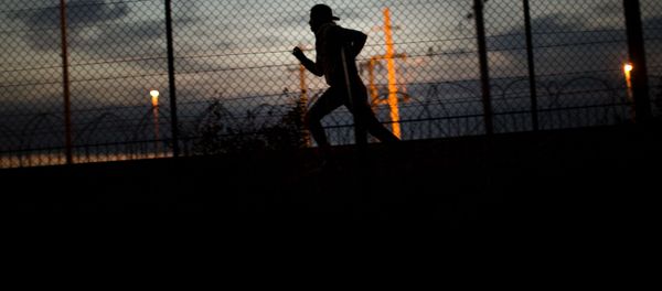 A migrant runs after crossing a fence as he attempts to access the Channel Tunnel, in Calais, northern France, Monday, Aug. 3, 2015. - Sputnik International
