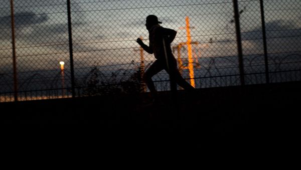 A migrant runs after crossing a fence as he attempts to access the Channel Tunnel, in Calais, northern France, Monday, Aug. 3, 2015. A migrant runs after crossing a fence as he attempts to access the Channel Tunnel, in Calais, northern France, Monday, Aug. 3, 2015. - Sputnik International