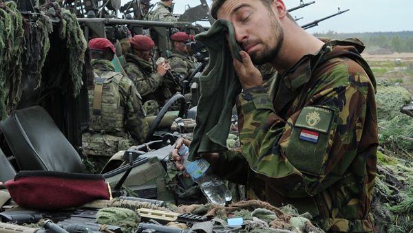 A Royal Dutch Army soldier wipes his face after the NATO Noble Jump exercise on a training range in Poland. - Sputnik International