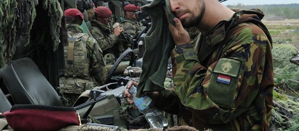 A Royal Dutch Army soldier wipes his face after the NATO Noble Jump exercise on a training range in Poland. A Royal Dutch Army soldier wipes his face after the NATO Noble Jump exercise on a training range in Poland. - Sputnik International