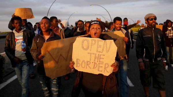 African migrants shout slogans during a protest on a motorway in Calais, France - Sputnik International