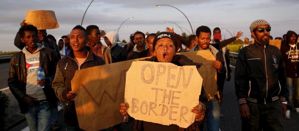 African migrants shout slogans during a protest on a motorway in Calais, France - Sputnik International