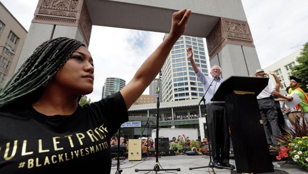Mara Jacqueline Willaford, left, holds her fist overhead as Democratic presidential candidate Sen. Bernie Sanders, I-Vt., waves to greet the crowd before speaking at a rally Saturday, Aug. 8, 2015, in downtown Seattle. - Sputnik International