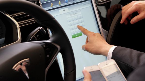 A guest experiences a Tesla car at a car handover ceremony in Shanghai as American electric carmaker Tesla Motors delivers their Model S carsto its first buyers in China on April 23, 2014 - Sputnik International
