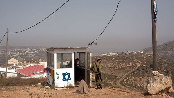 Israeli soldiers stand guard at their position at the West Bank Israeli outpost of Achiya, near the Palestinian village of Jalud Duma (background), on August 4, 2015, a week after the house of a Palestinian Dawabsha family was set on fire by suspected Jewish extremists, killing 18-month-old Ali Saad Dawabsha and critically injuring his parents and four-year-old brother - Sputnik International