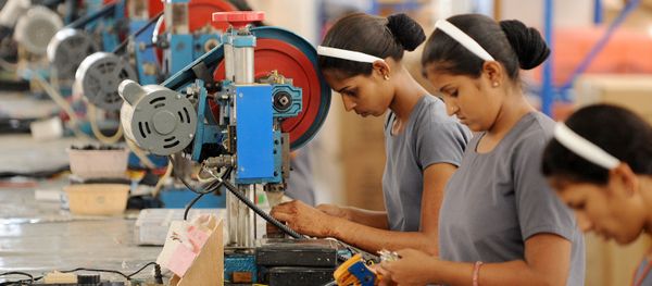 Indian women work at the electrical wiring section of the OREVA E Bike manufacturing facility near Samakhiali of Kutch district, some 240 kms from Ahmedabad on May 24, 2012 - Sputnik International