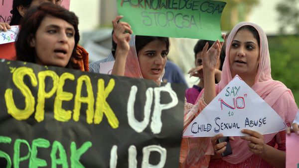 Pakistani rights activists carry placards as they shout slogans during a protest against a child sex abuse scandal in Islamabad on August 10, 2015 - Sputnik International