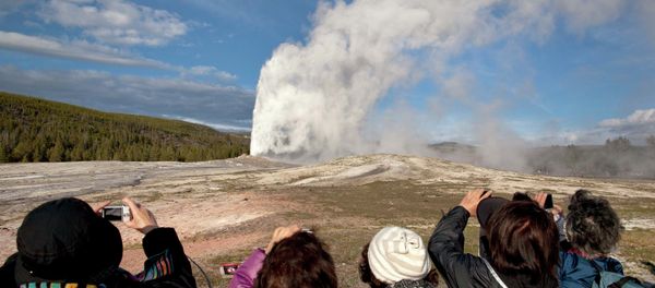 Tourists photograph Old Faithful erupting at Yellowstone National Park in Montana. - Sputnik International