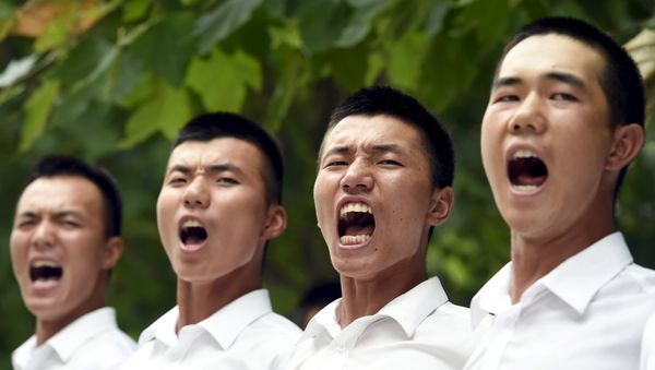Paramilitary policemen and members of a gun salute team shout slogans as they stand in formation during a training session for a military parade to mark the 70th anniversary of the end of the World War Two, at a military base in Beijing, China, August 1, 2015 - Sputnik International