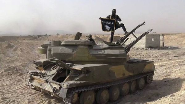 In this picture released on Wednesday, Aug. 5, 2015 by the Rased News Network a Facebook page affiliated with Islamic State militants, an Islamic State militant holds the group's flag as he stands on a tank they captured from Syrian government forces, in the town of Qaryatain southwest of Palmyra, central Syri In this picture released on Wednesday, Aug. 5, 2015 by the Rased News Network a Facebook page affiliated with Islamic State militants, an Islamic State militant holds the group's flag as he stands on a tank they captured from Syrian government forces, in the town of Qaryatain southwest of Palmyra, central Syri - Sputnik International
