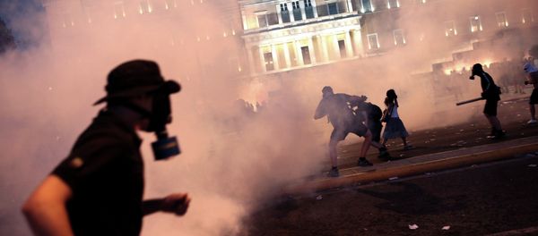 A protester clashes with riot police in front of the Greek Parliament in Athens on July 15, 2015 - Sputnik International
