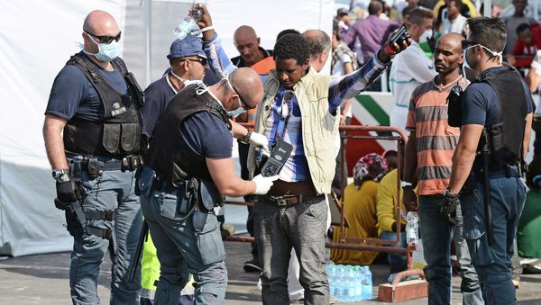 A police officer uses and hand held metal detector to check a man as he disembark from the patrol vessel Fiorillo of the Italian Coast Guard after it arrived in the port of Pozzallo on August 7, 2015 after saving some 387 migrants in the Sicilian Channel A police officer uses and hand held metal detector to check a man as he disembark from the patrol vessel Fiorillo of the Italian Coast Guard after it arrived in the port of Pozzallo on August 7, 2015 after saving some 387 migrants in the Sicilian Channel - Sputnik International