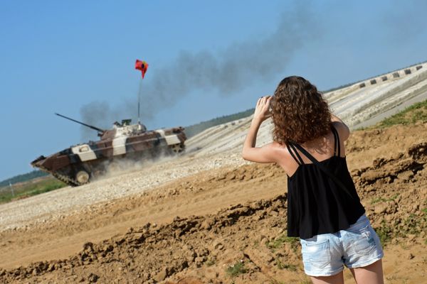 A spectator takes photos of an infantry combat vehicle of Venezuela's team during the Suvorov Onslaught competition of BMP-2 IFVs as part of the International Army Games 2015. The venue was held at the Alabino training field outside Moscow. - Sputnik International