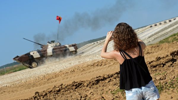 A spectator takes photos of an infantry combat vehicle of Venezuela's team during the Suvorov Onslaught competition of BMP-2 infantry combat vehicles held as part of the International Army Games 2015. - Sputnik International