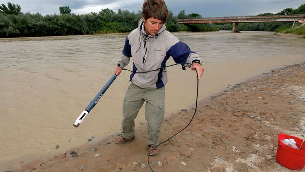 An official with the Utah Department of Environmental Quality takes a pH level reading from a probe in the San Juan River in Utah. - Sputnik International