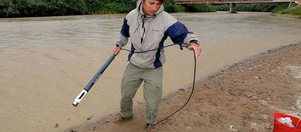 An official with the Utah Department of Environmental Quality takes a pH level reading from a probe in the San Juan River in Utah. An official with the Utah Department of Environmental Quality takes a pH level reading from a probe in the San Juan River in Utah. - Sputnik International