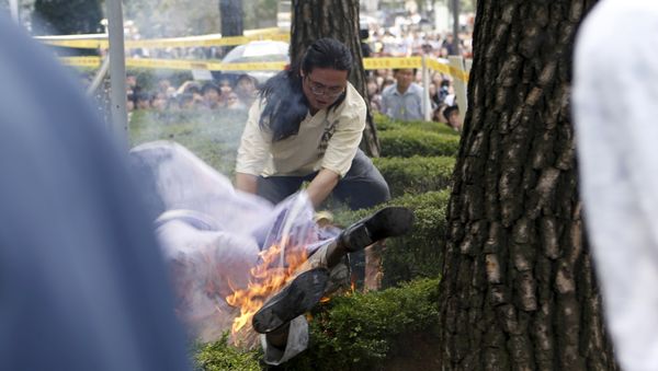 A man attempts to put out flames from another man (bottom) who set himself on fire during a weekly anti-Japan rally to demand for an official apology and compensation from the Japanese government in front of the Japanese embassy in Seoul, South Korea, August 12, 2015 A man attempts to put out flames from another man (bottom) who set himself on fire during a weekly anti-Japan rally to demand for an official apology and compensation from the Japanese government in front of the Japanese embassy in Seoul, South Korea, August 12, 2015 - Sputnik International