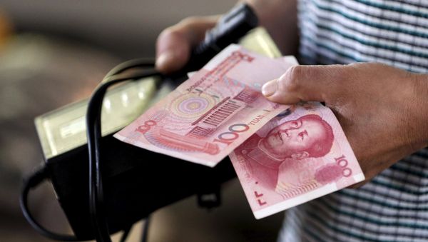 A customer holds a 100 Yuan note at a market in Beijing, August 12, 2015 A customer holds a 100 Yuan note at a market in Beijing, August 12, 2015 - Sputnik International