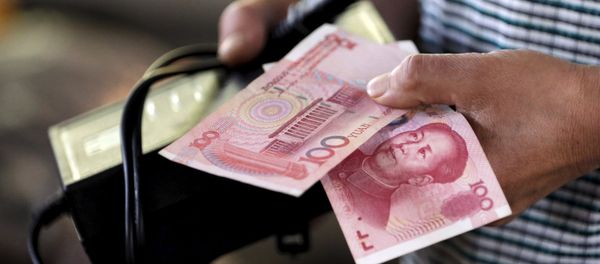 A customer holds a 100 Yuan note at a market in Beijing, August 12, 2015 - Sputnik International