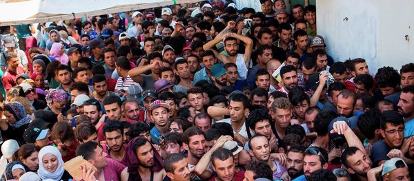File Photo: Syrian migrants and refugees gather at a makeshift migrant detention center at Kos' abandoned football stadium after crossing from Turkey, at the southeastern island of Kos, Greece, Wednesday, Aug. 12, 2015. - Sputnik International