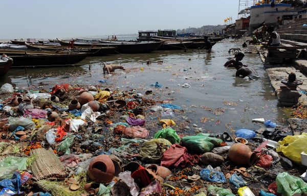 Indian scavengers look for coins and other valuable items from among the offerings of devotees in the Ganges at Varanasi  - Sputnik International