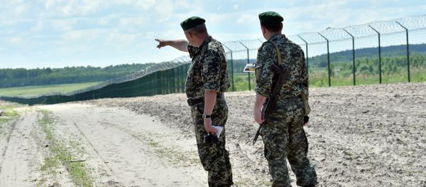 Ukrainian border guards patrol on July 2, 2015 along the barbed wire fence on the Senkivka border post, around 200 kilometres (125 miles) north of the Ukrainian capital Kiev. - Sputnik International