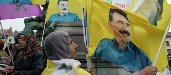 Demonstrators wave flags bearing pictures of jailed Kurdish rebel leader Abdullah Ocalan during a protest against the Turkish government in Brussels on July 28, 2015 - Sputnik International