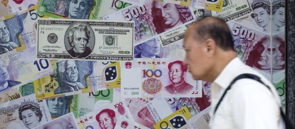 A man walks past an advertisement promoting China's renminbi (RMB) or yuan, U.S. dollar and Euro exchange services at foreign exchange store in Hong Kong, China, August 13, 2015 - Sputnik International