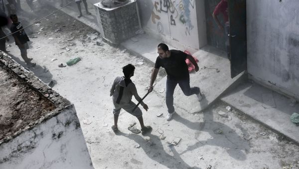 A policeman hits a migrant with a truncheon during a registration procedure at the stadium on the Greek island of Kos on August 11, 2015. A policeman hits a migrant with a truncheon during a registration procedure at the stadium on the Greek island of Kos on August 11, 2015. - Sputnik International