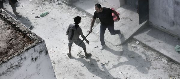 A policeman hits a migrant with a truncheon during a registration procedure at the stadium on the Greek island of Kos on August 11, 2015. - Sputnik International