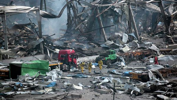 Rescue workers wearing chemical protective suits walk at the site of the explosions at the Binhai new district in Tianjin, China, August 14, 2015 - Sputnik International