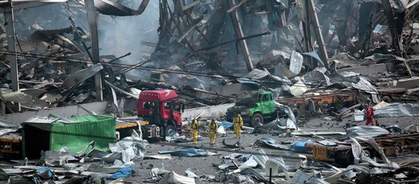 Rescue workers wearing chemical protective suits walk at the site of the explosions at the Binhai new district in Tianjin, China, August 14, 2015 - Sputnik International