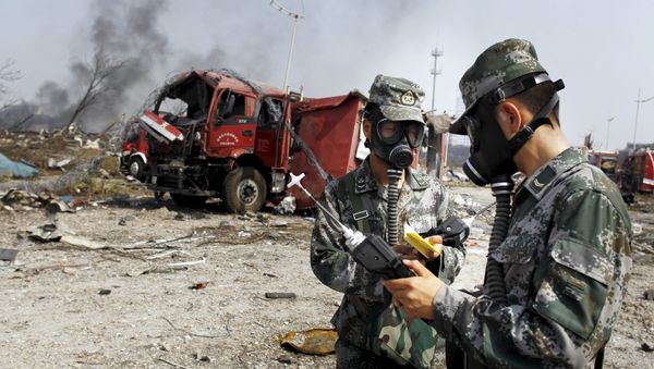 Soldiers of the People's Liberation Army anti-chemical warfare corps work next to a damaged firefighting vehicle at the site of Wednesday night's explosions at Binhai new district in Tianjin, China - Sputnik International