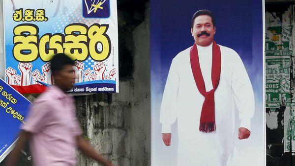 A man walks past a poster of Sri Lanka's former president Mahinda Rajapaksa ahead of a general election, in Galle August 14, 2015 - Sputnik International