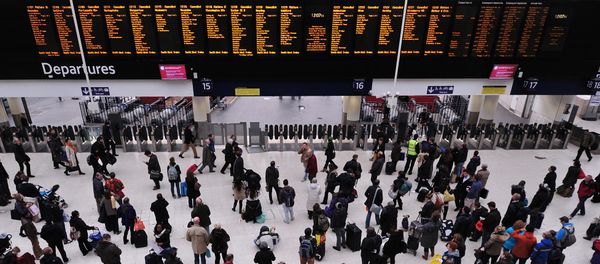 People wait with their luggage by the departure boards in Waterloo train station in central London People wait with their luggage by the departure boards in Waterloo train station in central London - Sputnik International