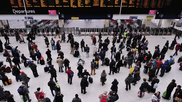 People wait with their luggage by the departure boards in Waterloo train station in central London People wait with their luggage by the departure boards in Waterloo train station in central London - Sputnik International